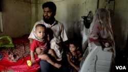 FILE - Mohammad Salim, a Rohingya Muslim refugee, with his wife and children, in a village, somewhere in India, May 27, 2019. Recently the Rohingya man was arrested and sent to jail by Indian police after he was charged as an illegal immigrant in India. (Shaikh Azizur Rahman/VOA)