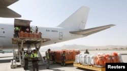FILE - Workers load export materials into a Cargo plane in Kabul, Afghanistan.