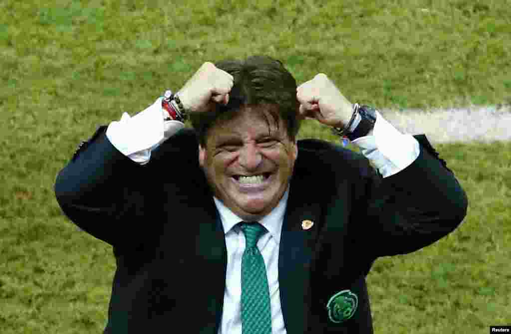 Pelatih Meksiko Miguel Herrera merayakan kemenangan timnya setelah menghasilkan gol ketiga dalam pertandingan melawan Kroasia di Pernambuco Arena di Recife, 23 Juni 2014.