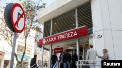 Depositors wait to enter a branch of Laiki Bank in Nicosia, Cyprus, March 29, 2013. 