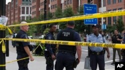 Polisi Washington berjaga di jalan M, Washington DC, dekat lokasi penembakan di gedung Angkatan Laut AS (Navy Yard), Senin (16/9).