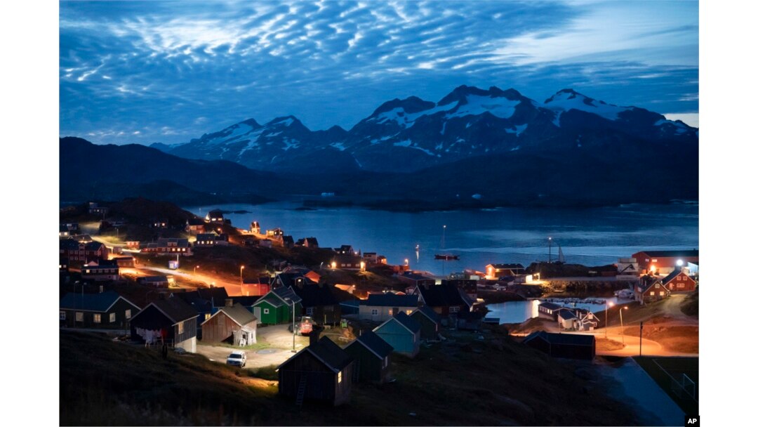 FILE - Homes are illuminated after sunset in Tasiilaq, Greenland, Aug. 16, 2019. Greenland has been controlled by Denmark for centuries, though its 57,000 people now govern their own domestic affairs.