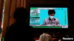 香港民众观看特首林郑月娥宣布不参选连任的电视报道（路透社2022年4月4日）