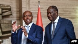 Le président ivoirien Alassane Ouattara, à gauche, et Patrice Motsepe, président de la CAF, après une réunion sur l'organisation de la CAN 2023 en Côte d'Ivoire, Abidjan, le 4 avril 2022.