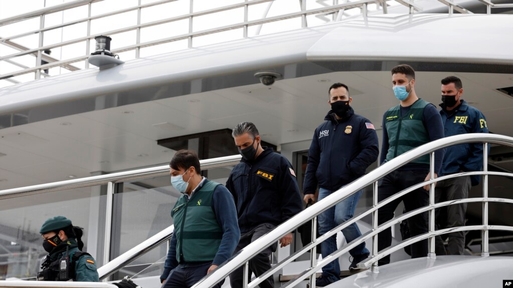 2022年4月4日，西班牙马略卡岛帕尔马市，国民警卫队陪同美国联邦调查局特工和一名国土安全部特工从名为“探戈”的游艇上走下来。他们正在搜查这艘由俄罗斯寡头维克塞尔伯格拥有的游艇。（美联社）(photo:VOA)