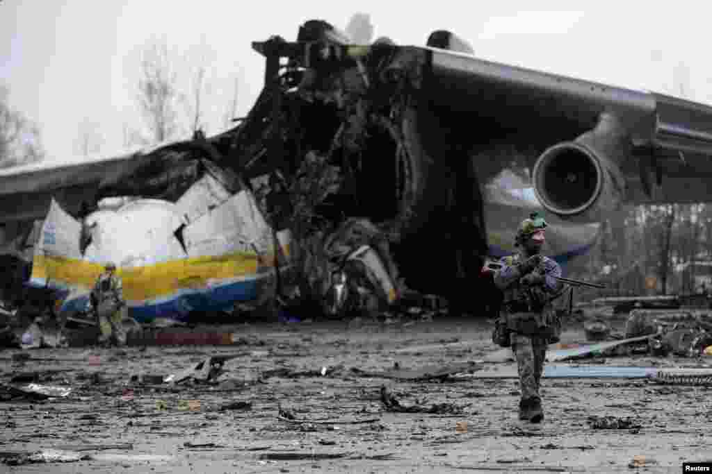 Un miembro del servicio ucraniano camina frente a un avión de carga Antonov An-225 Mriya, el avión de carga más grande del mundo, destruido por las tropas rusas, en un aeródromo en el asentamiento de Hostome.