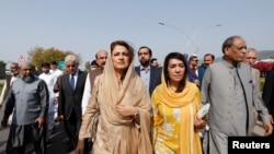 Pakistani lawmakers of the united opposition walk towards the parliament house building to cast their vote on a motion of no-confidence to oust Prime Minister Imran Khan, in Islamabad, Pakistan, Apr. 3, 2022.