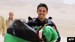 FILE - Jordan's Prince Hamza bin al-Hussein, then-president of the Royal Aero Sports Club of Jordan, carries a parachute during a media event in the Wadi Rum desert, April 19, 2011. 