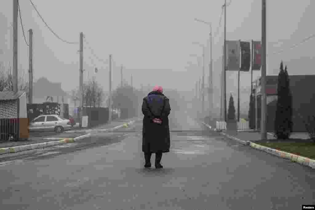 Una local camina por una calle vacía, mientras continúa el ataque de Rusia contra Ucrania, en la ciudad de Bucha.