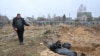 Un hombre muestra una fosa común con cadáveres en el poblado de Bucha, al noreste de Kiev, Ucrania, el 3 de abril de 2022.