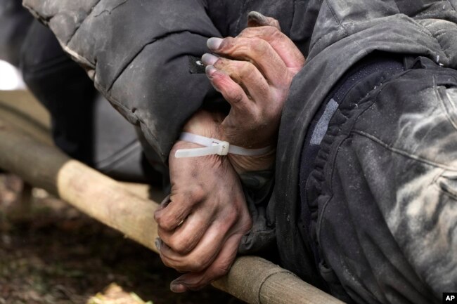 A dead civilian with his hands tied behind his back lies on the ground in Bucha close to Kyiv, Ukraine, April 4, 2022. (AP Photo/Efrem Lukatsky)