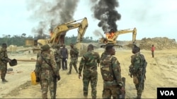 Soldiers Clash with civilians over burning escavator
