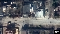 This satellite image released by Maxar Technologies on April 4, 2022 shows a view of Yablonska Street in Bucha, Ukraine, on March 19, 2022. The photograph disproves Russian claims that the bodies had been staged after Russian withdrawal. (©2022 Maxar Technologies / AFP)