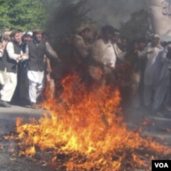 Para demonstran melakukan aksi pembakaran bendera AS di Jalalabad, dalam aksi protes atas pembakaran al-Quran di AS untuk hari ketiga, Minggu (3/4).