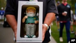 A shopper poses with his newly purchased garden gnome during a practice round for the Masters golf tournament, in Augusta, Ga., April 5, 2022.