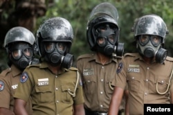 Sri Lanka police officers wearing gas masks stand guard on a road leading to the parliament building, after the government of President Gotabaya Rajapaksa lost its majority, amid the country's economic crisis, in Colombo, April 5, 2022.