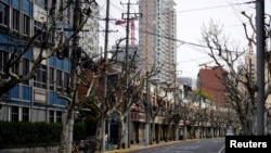 FILE - A police officer in a protective suit keeps watch on a street, as the second stage of a two-stage lockdown to curb the spread of the coronavirus disease (COVID-19) begins in Shanghai, China, Apr. 1, 2022. 