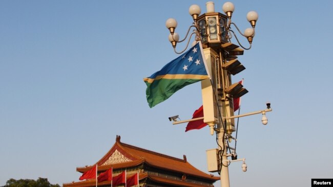 FILE - National flags of Solomon Islands and China flutter at the Tiananmen Square in Beijing, China, Oct. 7, 2019. The United States will launch a high-level strategic dialogue with Solomon Islands in September to address mutual security concerns.