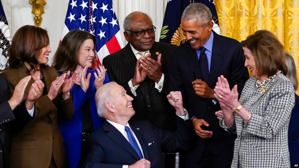 拜登总统在白宫东厅签署一项改进《平价医疗法》的行政命令时向前总统奥巴马致意。副总统哈里斯、众议院议长佩洛西等人也参加了这次活动。(2022年4月5日)(photo:VOA)