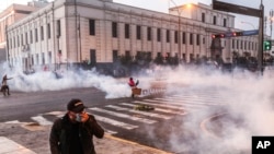 Nubes de gases lacrimógenos envuelven una calle mientras manifestantes antigubernamentales chocan con la policía en el centro de Lima, Perú, el martes 5 de abril de 2022.