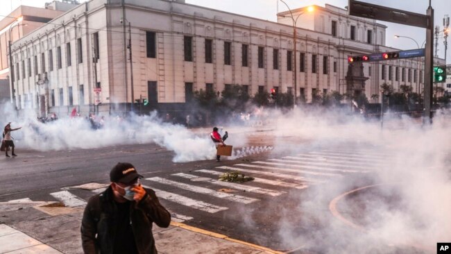 Nubes de gases lacrimógenos envuelven una calle mientras manifestantes antigubernamentales chocan con la policía en el centro de Lima, Perú, el martes 5 de abril de 2022.