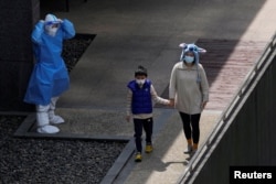 Residents line up for nucleic acid testing at a residential area, during the second stage of a two-stage lockdown to curb the spread of the coronavirus disease (COVID-19), in Shanghai, China April 4, 2022. REUTERS/Aly Song