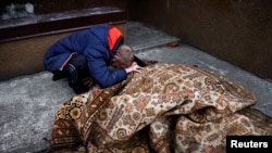 乌克兰布查镇的一个男子在哀悼他的一名被俄军杀死的朋友。（2022年4月5日）