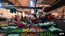 Seorang pedagang tampak tertidur ketika menunggu pembeli datang pada kios dagangannya di salah satu pasar tradisional di Jakarta, pada 3 April 2022. (Foto: AFP/Adek Berry)