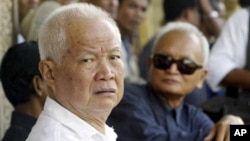 Former Khmer Rouge leaders Khieu Samphan, left, and Nuon Chea, right, look on during the funeral for Khieu Ponnary, the first wife of Khmer Rouge leader Pol Pot, in 2003. 