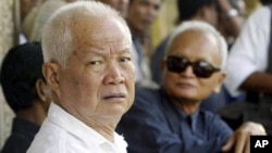 Former Khmer Rouge leaders Khieu Samphan, left, and Nuon Chea, right, look on during the funeral for Khieu Ponnary, the first wife of Khmer Rouge leader Pol Pot, file photo. 