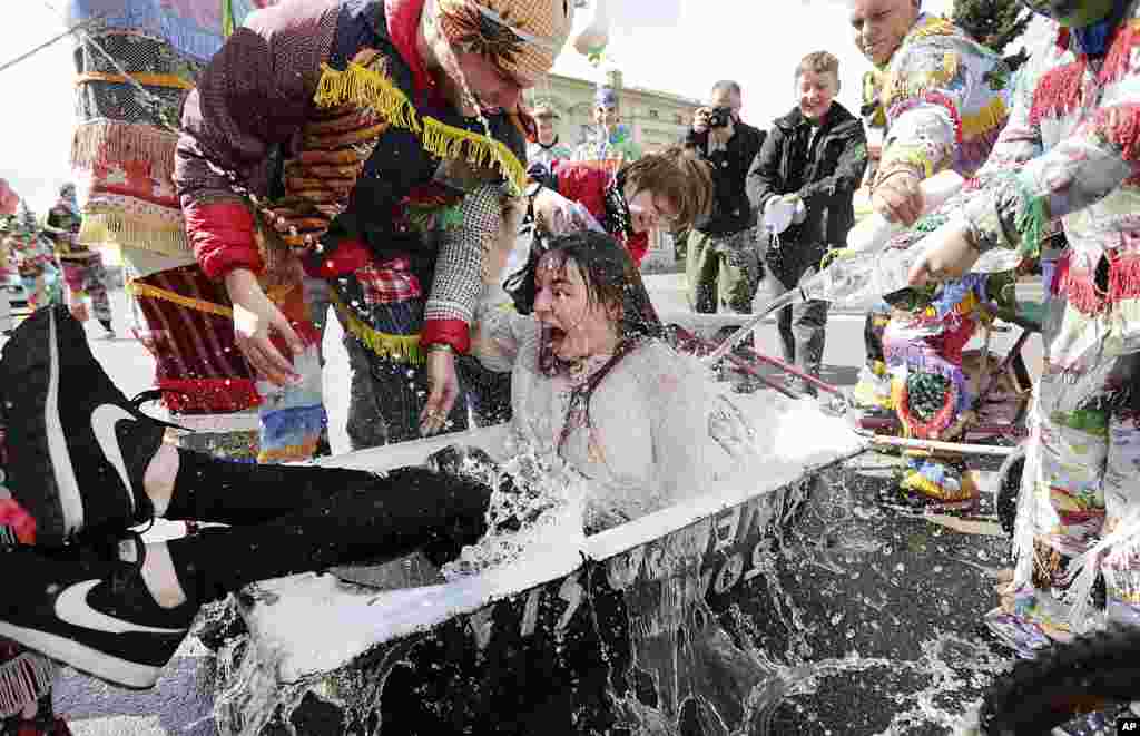 A girl is splashed with water by boys following a Polish Wet Easter Monday tradition, in Wilamowice, Poland.