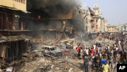 People gather at the site of a fire, a result of an explosion at a warehouse where witnesses say fireworks were stored, December 26, 2012. 