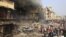 People gather at the site of a fire, a result of an explosion at a warehouse where witnesses say fireworks were stored, December 26, 2012. 