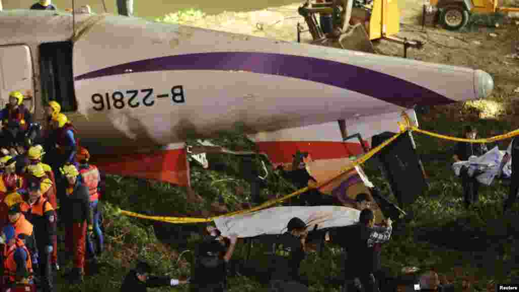 Une équipe de sauveteurs des restes de corps de passagers rivière après qu&#39;un avion de TransAsia s&#39;est abimé dans une rivière dans la nouvelle ville de Taipei.