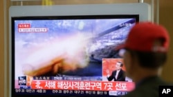 Người dân Nam Triều Tiên theo dõi tin tức về cuộc diễn tập bằng đạn thật của Bắc Triều Tiên tại nhà ga xe lửa ở Seoul, ngày 31/3/2014.