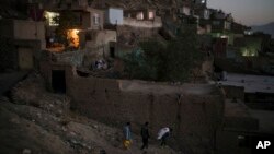 FILE - Afghans carry supplies to their home at dusk in Kabul, Afghanistan, Sept. 14, 2021. 