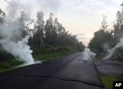 Steam rises from cracks in the road shortly before a fissure opened up on Kaupili Street in the Leilani Estates subdivision, May 4, 2018, in Pahoa, Hawaii, in this image released by the U.S. Geological Survey.