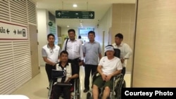 Cambodian opposition​ CNRP lawmakers Nhay Chamroeun and Kong Saphea are seen in wheelchairs at Phyathai hospital in Bangkok on Tuesday, October 27, 2015 after being beaten by protesters in Phnom Penh, Cambodia on Monday. (Courtesy of Nhay Chamroeun)