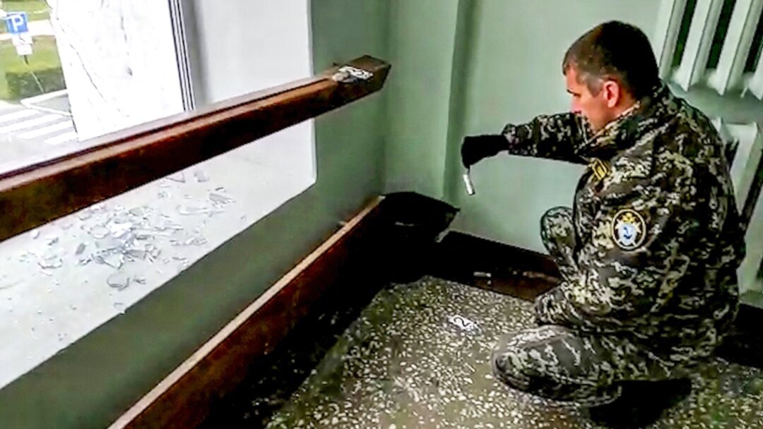 Seorang penyelidik tengah memeriksa lokasi penembakan di Universitas Perm, Rusia, 20 September 2021. (AFP PHOTO / Investigative Committee of Russia)