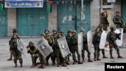 30일 요르단강 서안지구에서 이스라엘 군인들이 도널드 트럼프 미국 대통령의 중동평화구상에 항의하는 팔레스타인인 시위대와 대치하고 있다. 