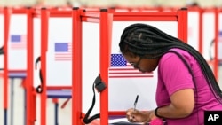 A voter fills out her ballot during the Kentucky Primary at the Kentucky Exposition Center in Louisville, Ky., June 23, 2020.