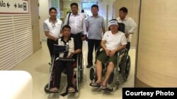 Cambodian opposition​ CNRP lawmakers Nhay Chamroeun and Kong Saphea are seen in wheelchairs at Phyathai hospital in Bangkok on Tuesday, October 27, 2015 after being beaten by protesters in Phnom Penh, Cambodia on Monday. (Courtesy of Nhay Chamroeun)