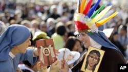 Kaluđerice drže ikone sa likom Kateri Tekakvite