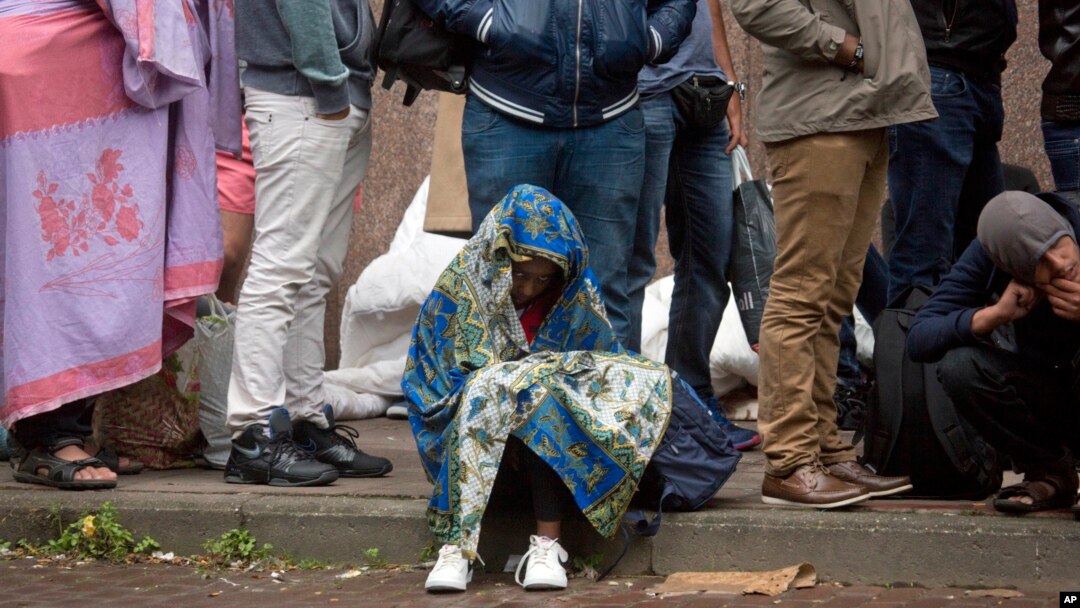 FILE - In this Sept. 1, 2015 file photo, a young child waits in line at a migrant reception center in Brussels. Belgian migration minister Theo Francken on Dec. 6, 2018, said he wants no part of a United Nations pact on safe and orderly migration.