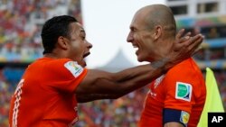 Pemain Belanda Memphis Depay (kiri) merayakan kemenangan atas Chile dengan anggota tim Arjen Robben di Sao Paulo (23/6). 