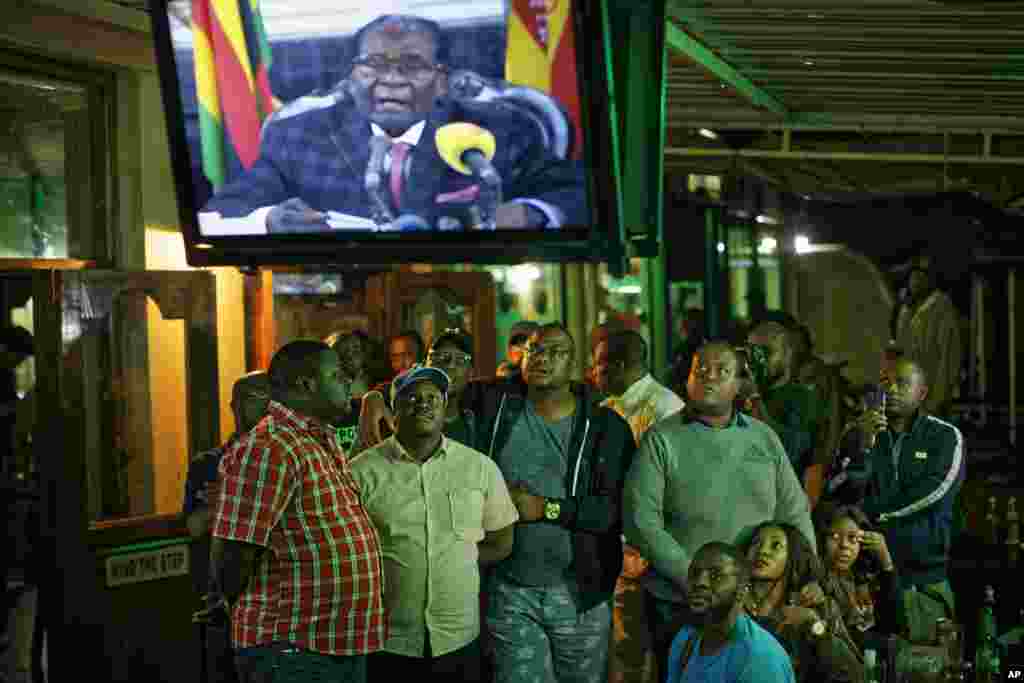 Zimbabweans watch a televised address to the nation by President Robert Mugabe at a bar in downtown Harare, Nov. 19, 2017.