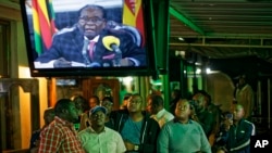 Les Zimbabwéens regardent une allocution télévisée adressée à la nation par le président Robert Mugabe dans un bar du centre-ville de Harare, au Zimbabwe, le 19 novembre 2017.