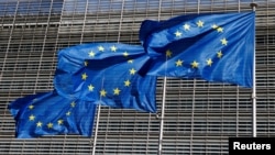 FILE - European Union flags flutter outside the EU Commission headquarters in Brussels, Belgium, June 17, 2022.