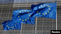 FILE - European Union flags flutter outside the EU Commission headquarters in Brussels, Belgium June 17, 2022.