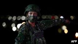 A member of the military gestures during Taiwan's Southern armored brigade live-fire exercises in Pingtung county, southern Taiwan, on Sept. 6, 2022.